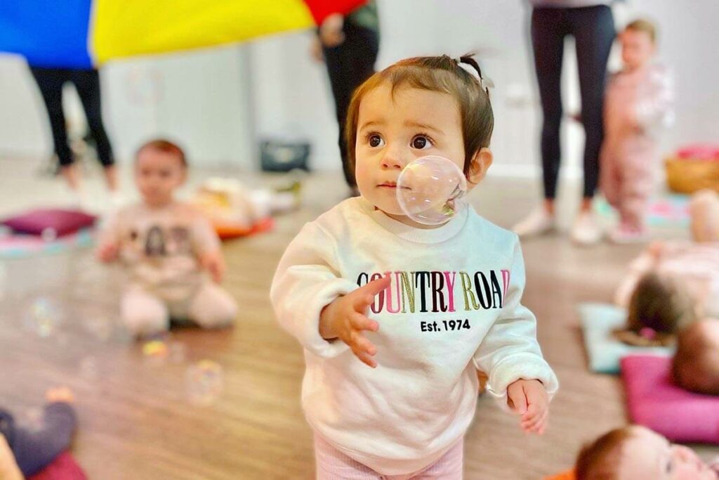 toddler-under-colourful-parachute-with-bubbles